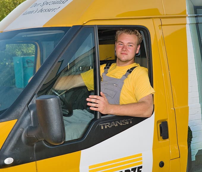 Ein SCHWARZE Mitarbeiter sitzt im Wagen und schaut aus dem Fenster.