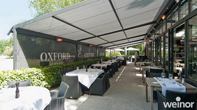 Blick auf die Terrasse eines Restaurants. Es sind Markisen mit Heizelementen installiert.